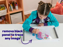 Child tracing a unicorn on a white light board panel