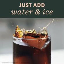 Cold brew concentrate being poured over ice in a glass, ready with water & ice