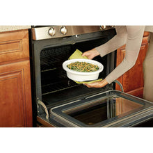 Mini slow cooker placed in oven, green casserole dish visible