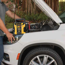 Jump starter and air compressor being used near a car front wheel