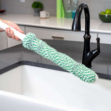 Twist mop with green handle and green-and-white yarn head over sink