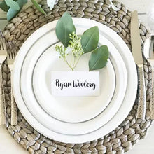 White dinner plate with stacked plate set and folded paper card on top