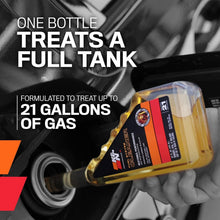 K&N fuel system cleaner bottle held near engine, black label with orange stripe.