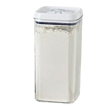 Clear square food container with white flip lid, filled with white powder
