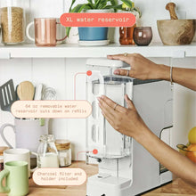 White single-serve coffee maker with grinder chamber and clear water reservoir
