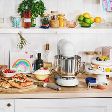 White stand mixer on countertop with stainless bowl
