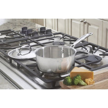 Stainless steel saucepan with lid on a gas cooktop