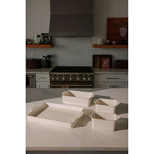Cream ceramic nesting bakeware set with four empty square and rectangular trays