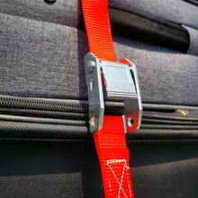 Close-up of metal cam buckle clamping a red tie-down strap