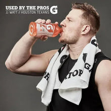 Athlete drinking from a sports drink bottle, with towel over shoulder
