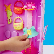 Purple doll wardrobe playset with hanging outfits, hand holding teal dress piece