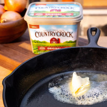 Country Crock Original buttery spread tub with lid near a skillet with melted butter