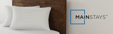 White bed pillow set with two rectangular pillows on a wooden headboard