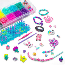 Rainbow Loom kit accessories with teal rubber bands, charms, pink tool, bracelet strings