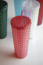 Red plastic tumbler with lid and straw, textured diamond pattern