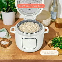 White electric rice cooker with open lid and filled inner pot of white rice