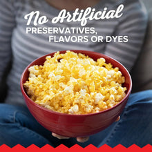 Butter-flavored popped corn in red bowl held in hands