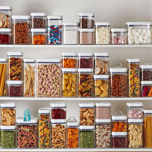 Airtight pantry storage containers lined up with clear bins and white lids, assorted dry contents