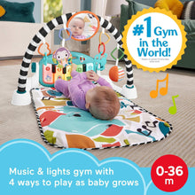 Blue baby playmat with piano arch and hanging toys, baby lying on colorful panel