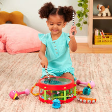 Child playing a red animal toy drum with striped mallet and small shakers