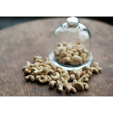 Cashew nuts scattered with a glass jar filled with cashews