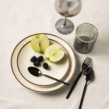 Off-white ceramic dinner plate with thin gold rim, top view
