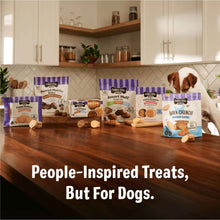 Multiple Three Dog Bakery soft-baked treat bags displayed on a kitchen counter