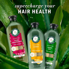 Hair conditioner bottles with green, yellow, and pink labels and black caps