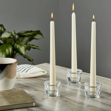 Clear glass candleholders holding three taper candles with glass cup bases