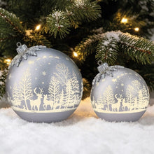 Two silver Christmas baubles with deer, trees, and hanging caps