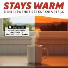 Black coffee maker on countertop with empty carafe and warming base