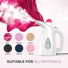 Handheld steamer with white body and pink nozzle cap, releasing steam onto fabric