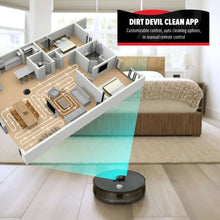 Black robot vacuum on light wood floor near sofa and bed