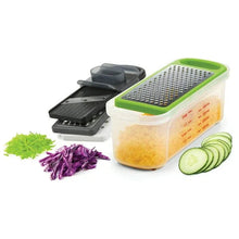 Clear storage container with green grater plate and black slicer, with shredded and sliced vegetables