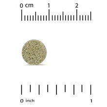 Round andrographis extract tablet next to measurement scale