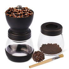Black manual coffee grinder with glass jar of grounds and coffee bean container
