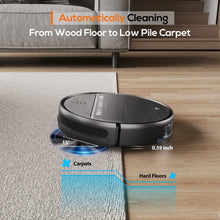 Black robot vacuum with blue mop pad near a carpet and hardwood floor