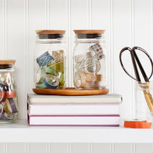 Ball wide-mouth mason jars with metal lids and bands, clear glass, on shelf.
