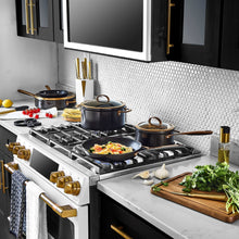 Non-stick skillet with speckled black interior and bronze handle on stovetop