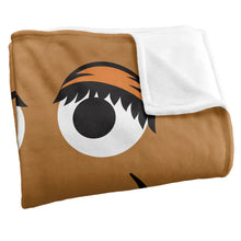Folded tan throw blanket with large eye graphic and white reverse side