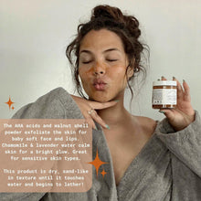 Gold scrub jar with white Bright Star Scrub label, held near face