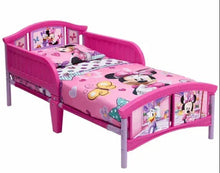 Pink toddler bed with Minnie Mouse printed quilt and four-panel side rails