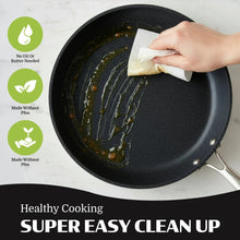 Black speckled nonstick frying pan being wiped clean with paper towel, stainless handle