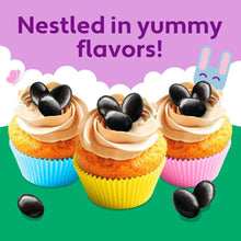 Cupcakes with piped frosting topped with black licorice jelly beans