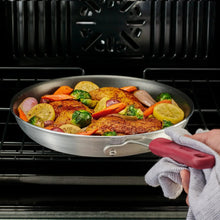 Nonstick fry pan filled with sautéed chicken and mixed vegetables, viewed from front