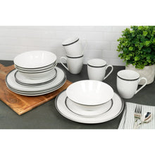 Ceramic dinnerware set with plates, bowls, and mugs featuring black rim bands