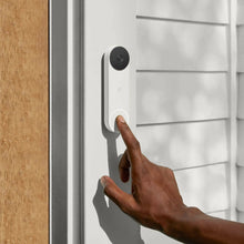 Ash gray wireless video doorbell mounted on wall with finger pressing door button