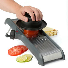 Adjustable chef’s mandoline slicer with hand guard pressing a carrot and zucchini