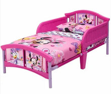 Pink toddler bed with Minnie Mouse graphic bedding and side guard rails