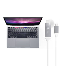 USB-C to HDMI cable with gray plugs connected beside a laptop